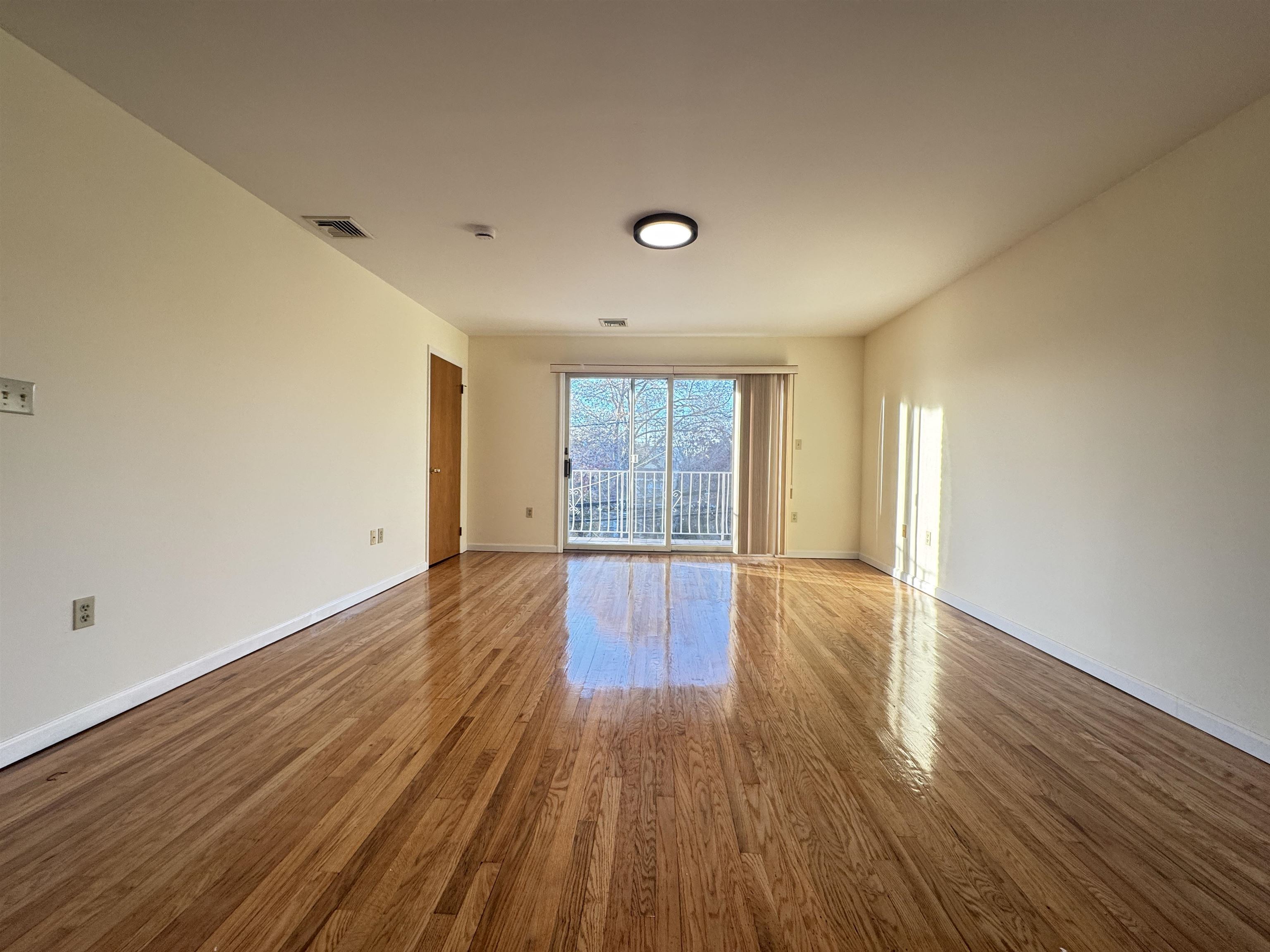 4414 Liberty Avenue, Unit 2 North Bergen, NJ 07047 - Photo 2 of 14 a view of an empty room with wooden floor and window