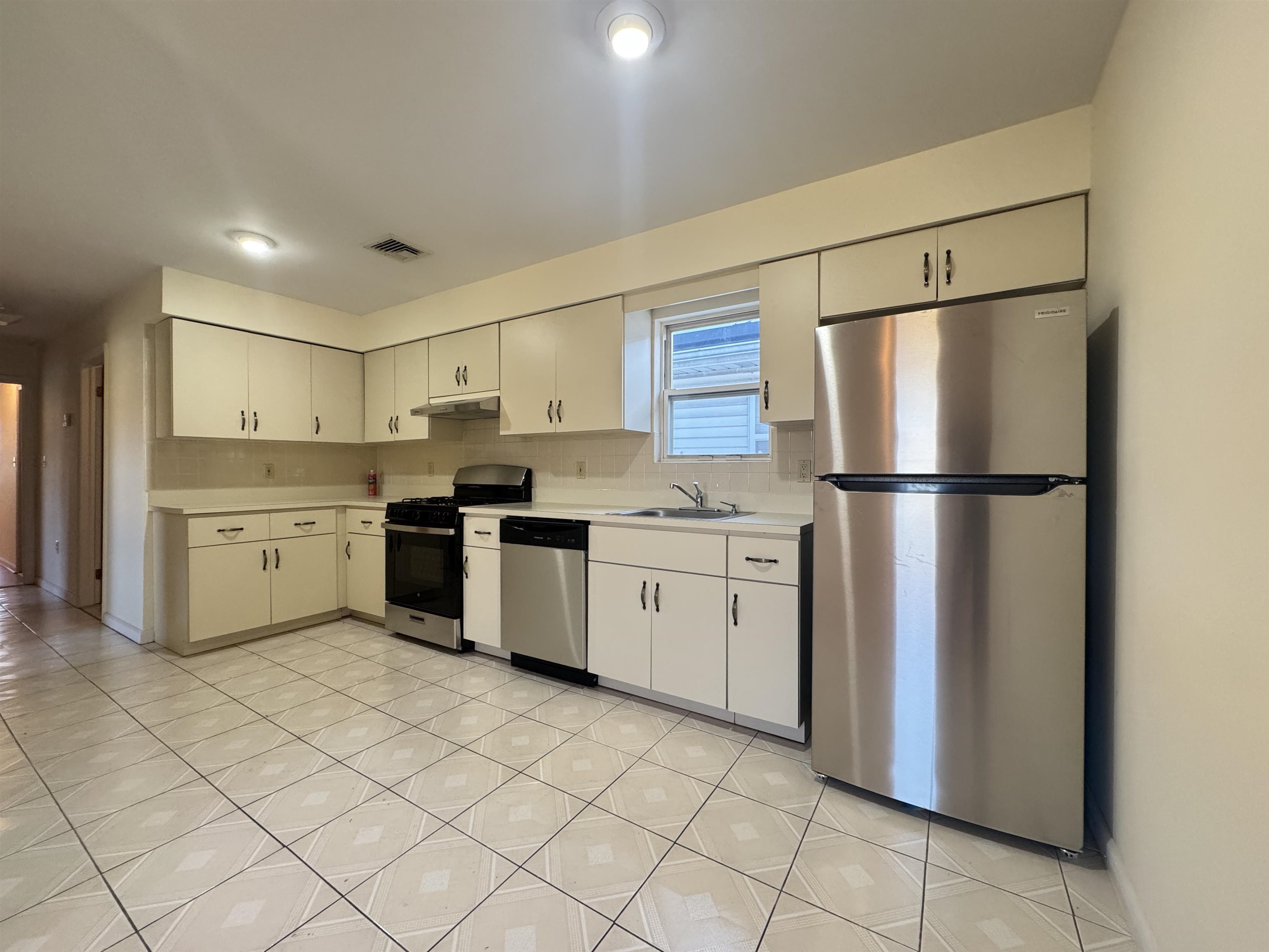 4414 Liberty Avenue, Unit 2 North Bergen, NJ 07047 - Photo 5 of 14 a kitchen with white cabinets a sink appliances and a counter space