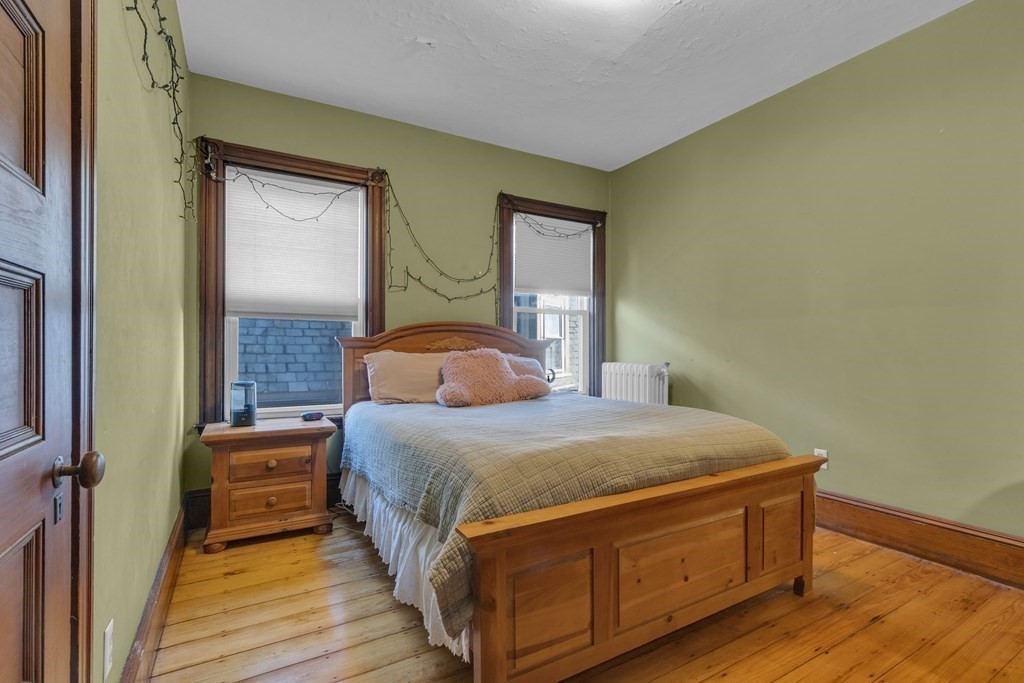 100 Calumet Street Boston, MA 02120 - Photo 14 of 42 a bedroom with a bed and wooden floor