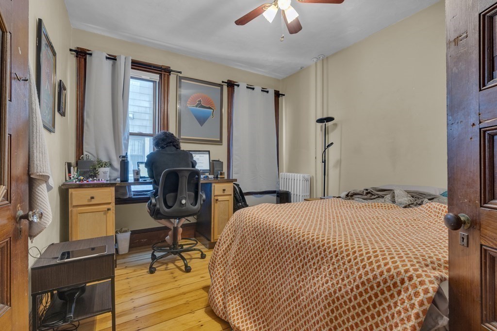 100 Calumet Street Boston, MA 02120 - Photo 8 of 42 a bedroom with a bed and a chandelier