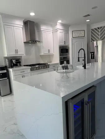 a kitchen with stainless steel appliances granite countertop a sink a stove and cabinets