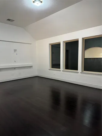 a view of a small space with wooden floor and a window