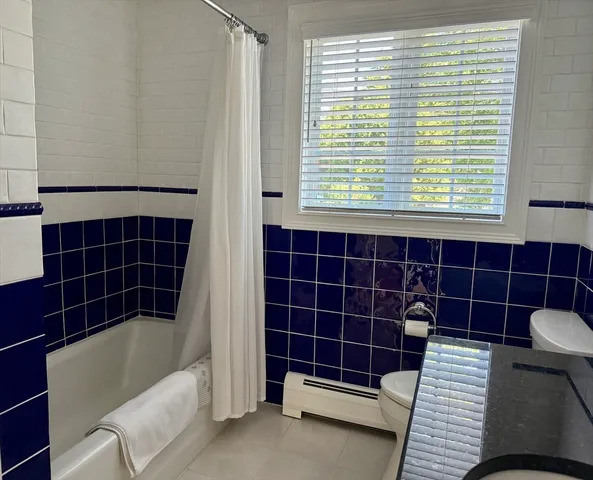a bathroom with a bathtub a window and a shower