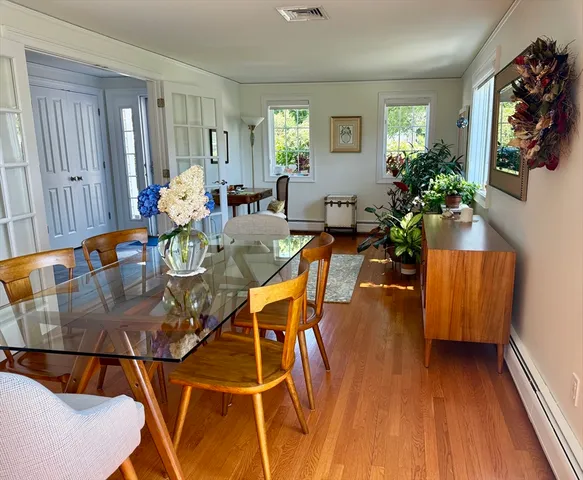 a dining room with furniture potted plants and wooden floor