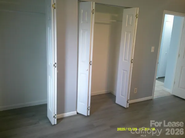 an empty room with wooden floor and closet