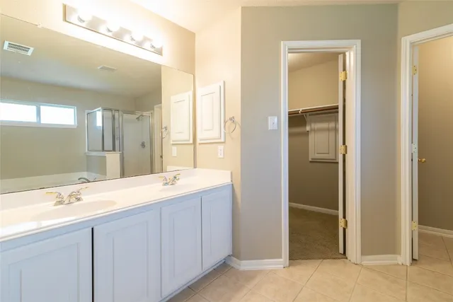 a bathroom with a double vanity sink and a mirror