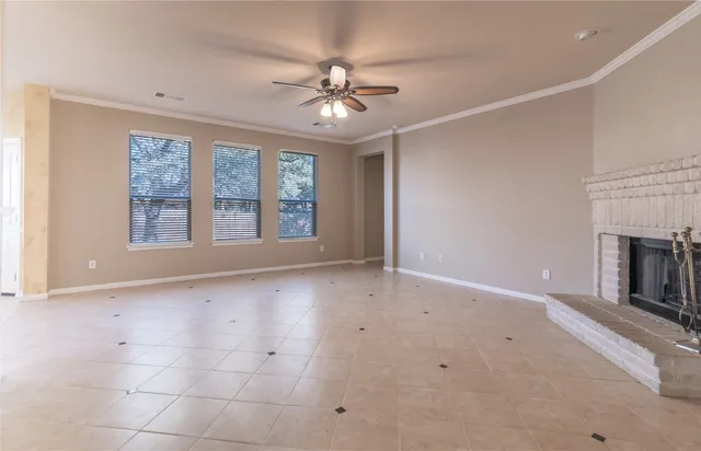a view of an empty room with a fireplace and a window