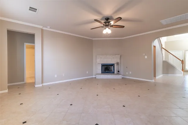 an empty room with ceiling fan and window