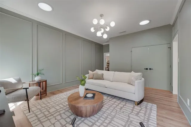 a living room with furniture a chandelier and a flat screen tv