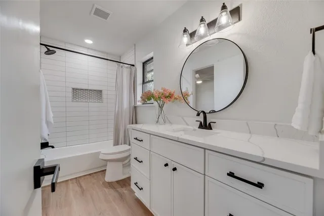 a bathroom with a granite countertop toilet sink and mirror