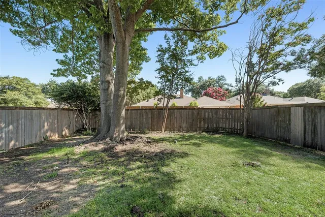 a backyard of a house with table and chairs