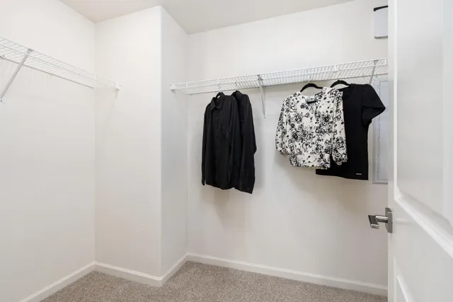 a view of walk in closet with clothes