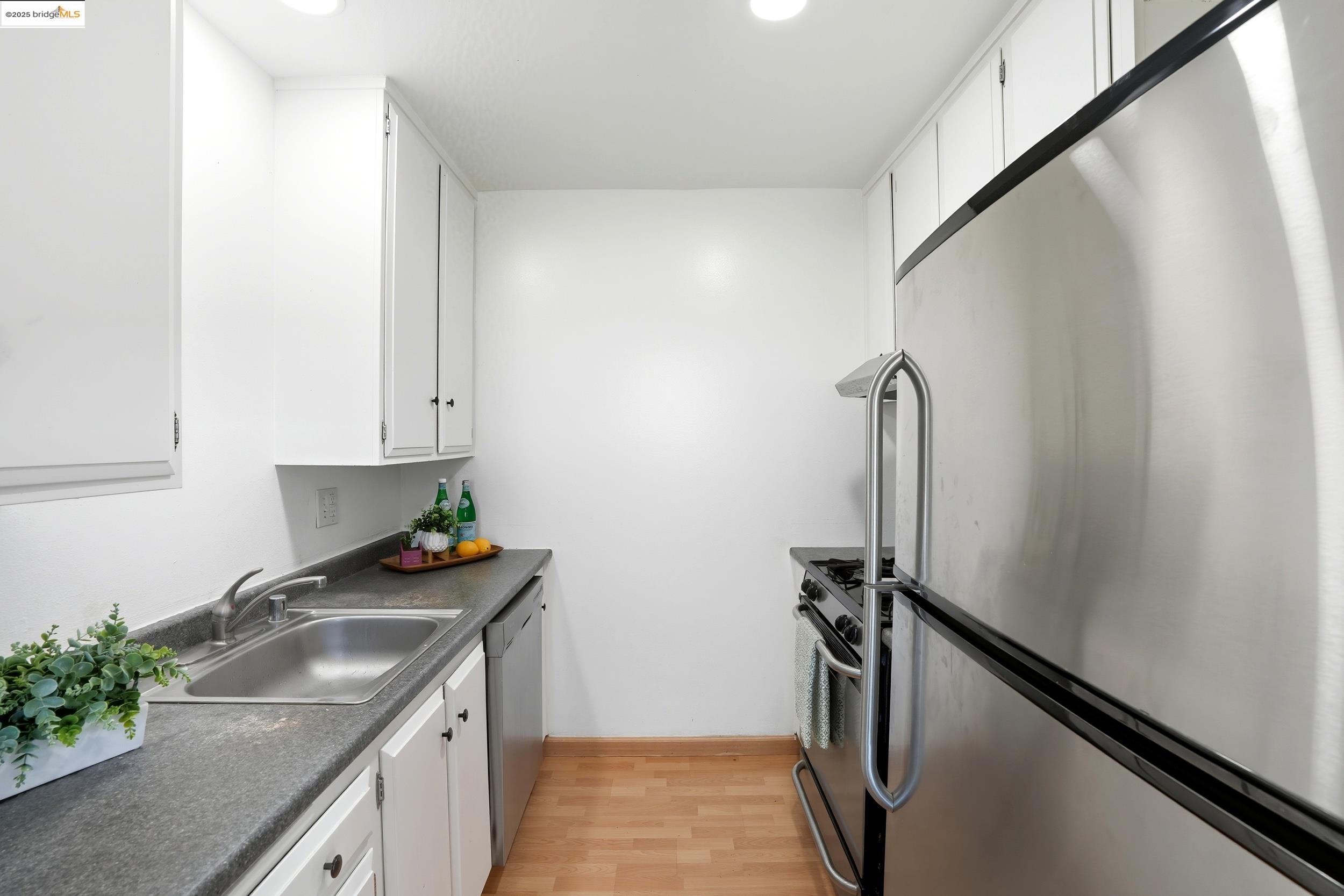 2036 Sierra Road, Unit 2 Concord, CA 94518 - Photo 10 of 32 Kitchen with appliances with stainless steel finishes, white cabinets, dark countertops, light wood-type flooring, and recessed lighting