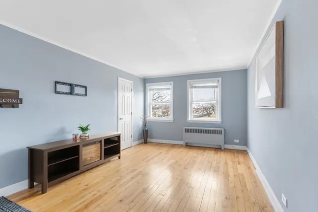 a view of empty room with wooden floor and cabinet