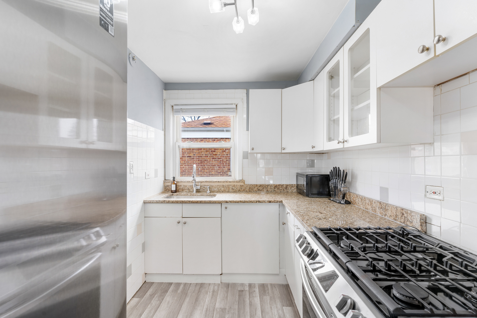2204 South 9th Avenue, Unit 2 Broadview, IL 60155 - Photo 6 of 16 a kitchen with sink stove and cabinets