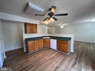 a kitchen with stainless steel appliances granite countertop a stove a sink dishwasher and a refrigerator with wooden floor