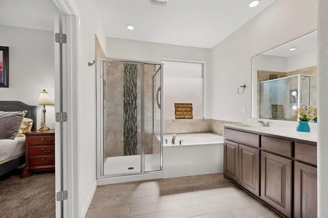 a bathroom with a tub a sink and a large mirror