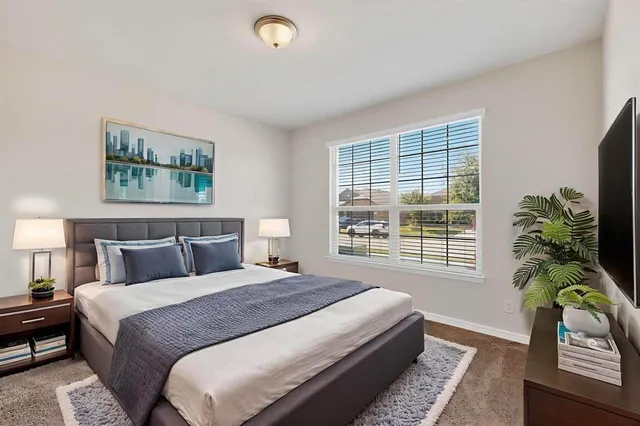 a bedroom with a bed painting and window