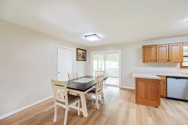 a dining room with wooden floor and stainless steel appliances