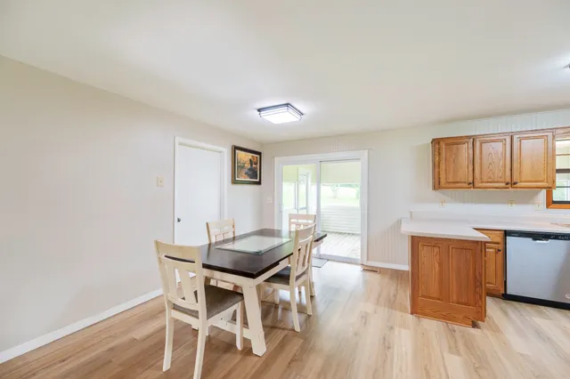 a dining room with wooden floor and stainless steel appliances