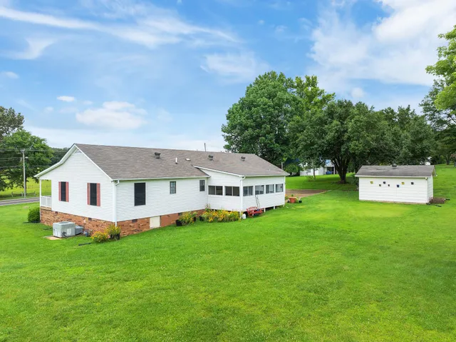 a front view of a house with a yard and trees