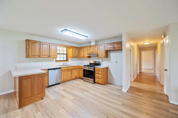 a large kitchen with a lot of counter space and wooden floor