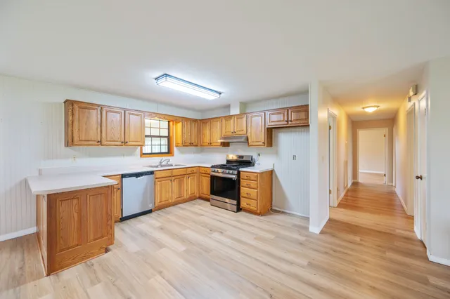 a large kitchen with a lot of counter space and wooden floor