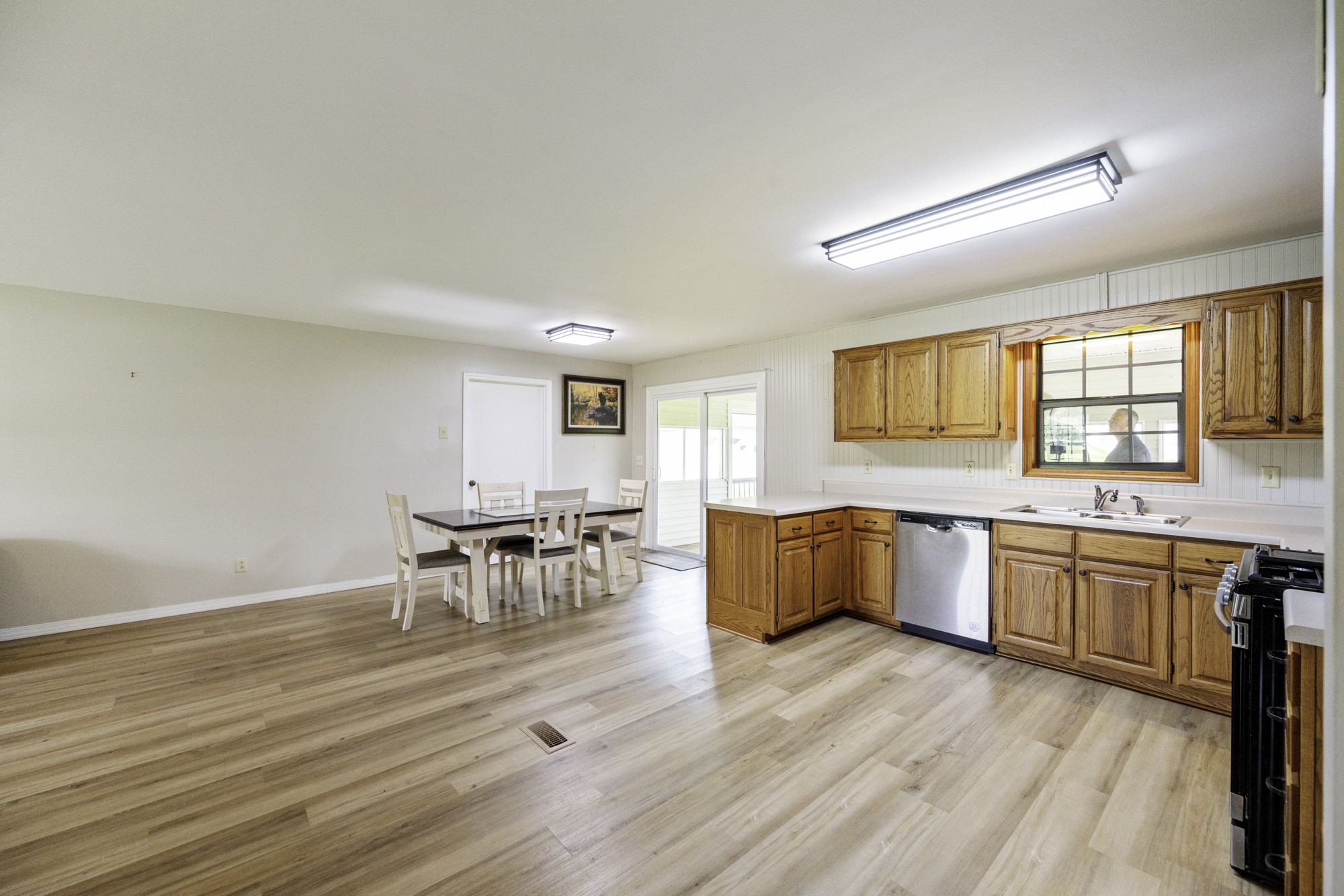 17930 West Main Street Huntingdon, TN 38344 - Photo 9 of 28 a large kitchen with granite countertop a stove a sink a dining table and chairs with wooden floor