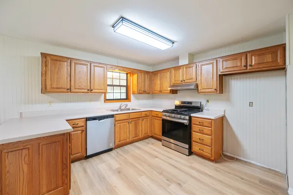 a kitchen with stainless steel appliances granite countertop a stove a sink dishwasher and a refrigerator