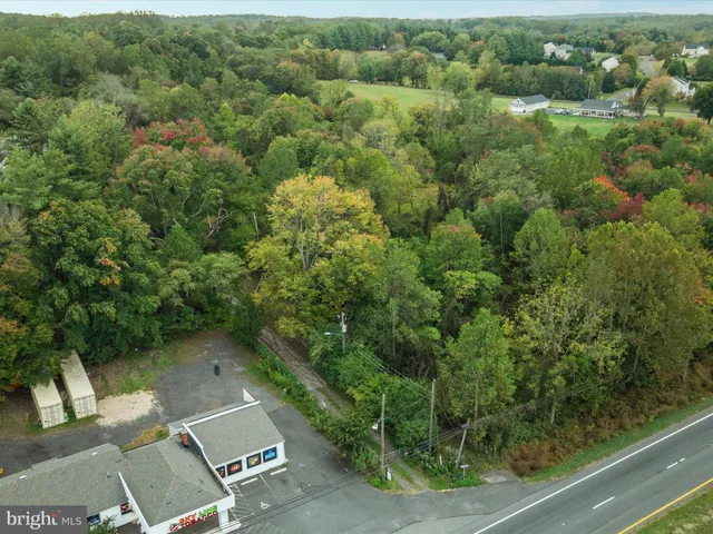 an aerial view of residential house with outdoor space and trees all around