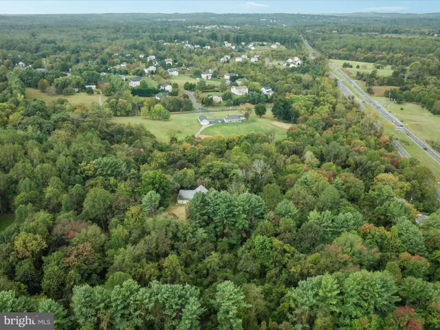 an aerial view of residential houses with outdoor space and trees