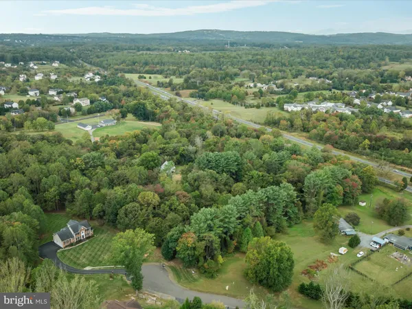 an aerial view of residential houses with outdoor space and trees