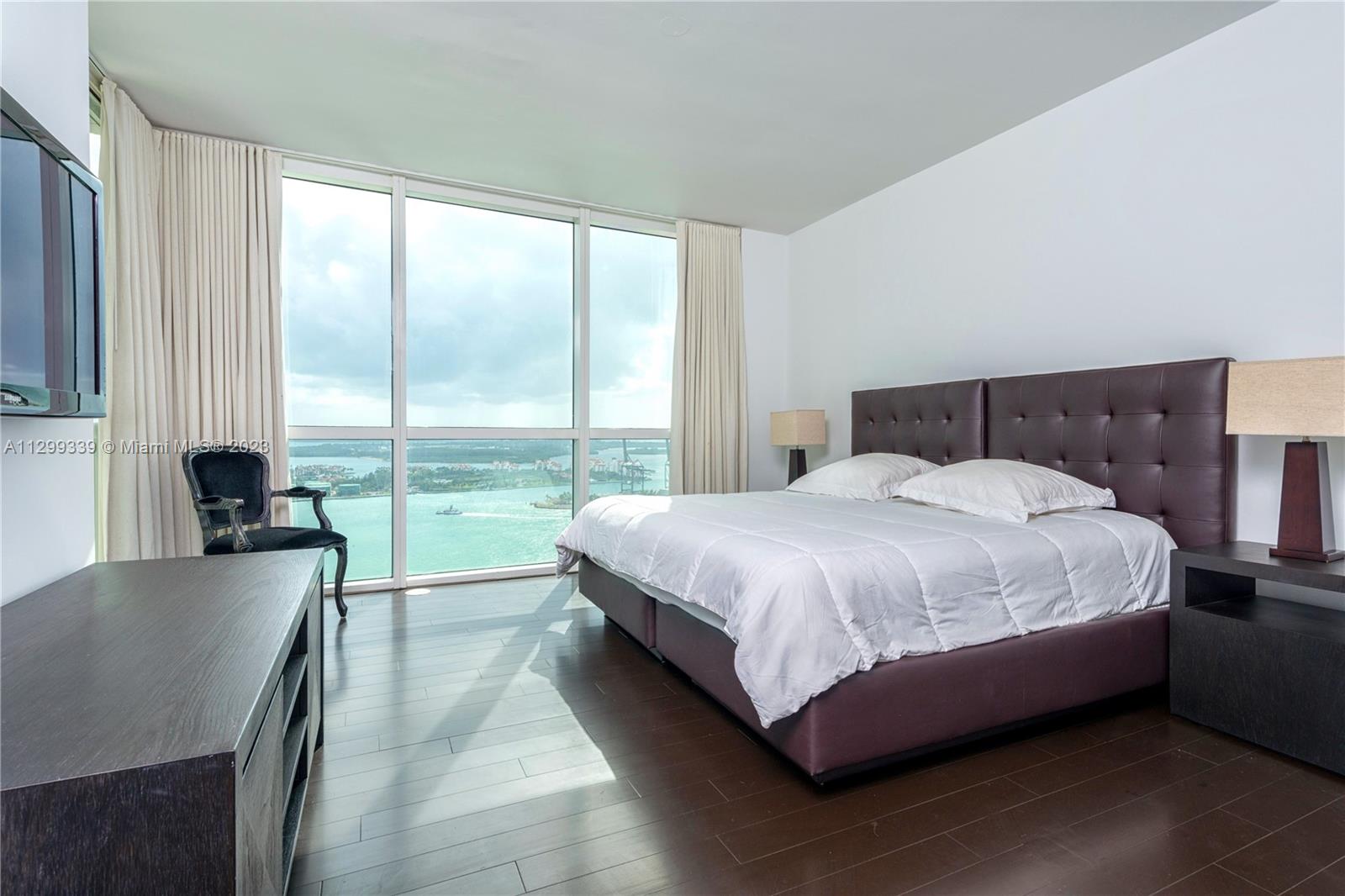 450 Alton Road, Unit 3603 Miami Beach, FL 33139 - Photo 17 of 25 a bed sitting in a spacious bedroom next to a window