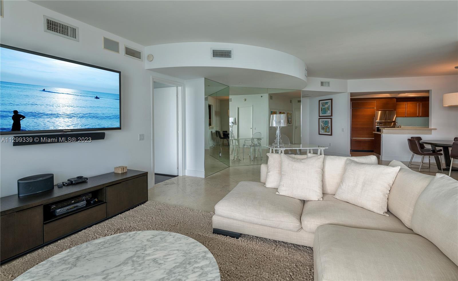 450 Alton Road, Unit 3603 Miami Beach, FL 33139 - Photo 5 of 25 a living room with furniture and a flat screen tv