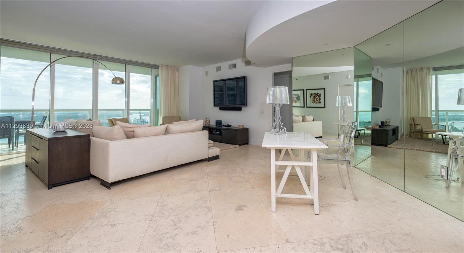 450 Alton Road, Unit 3603 Miami Beach, FL 33139 - Photo 10 of 25 a living room with furniture and a flat screen tv