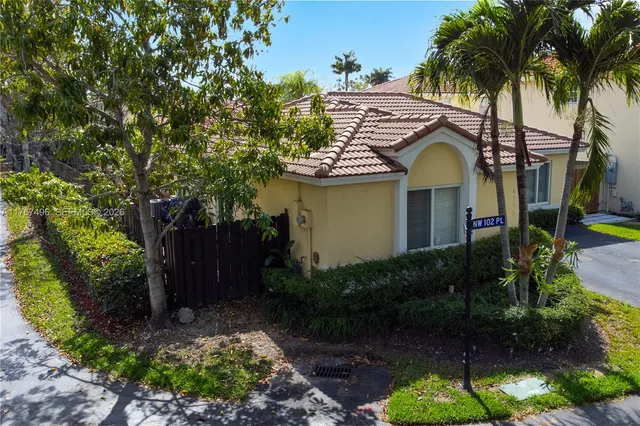 a view of a house with a yard and potted plants