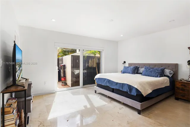 a spacious bedroom with a bed and a flat screen tv