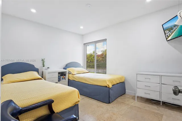 a bedroom with two beds and window