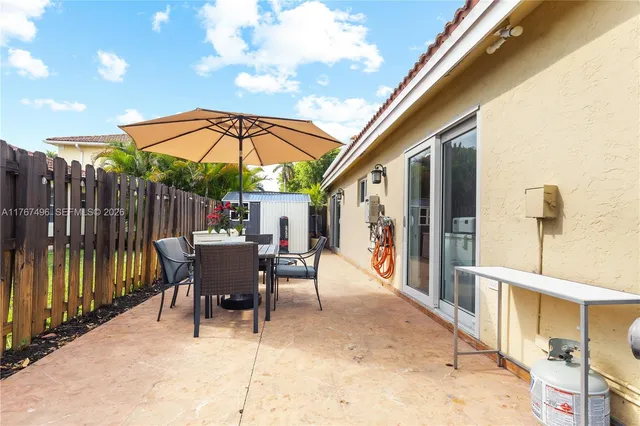 a view of a patio with a table and chairs under an umbrella