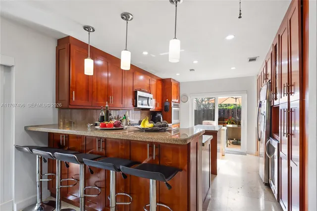 a kitchen with stainless steel appliances granite countertop a stove a sink and a refrigerator