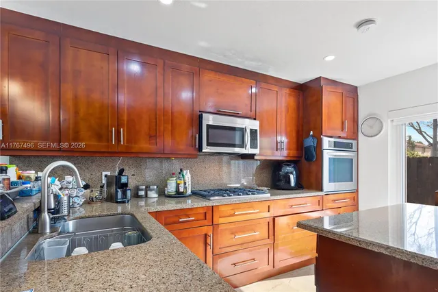 a kitchen with stainless steel appliances granite countertop a sink and a stove