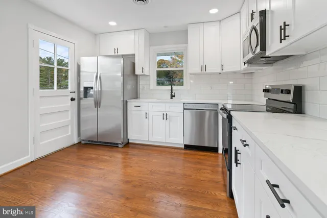 an empty room with wooden floor and closet area