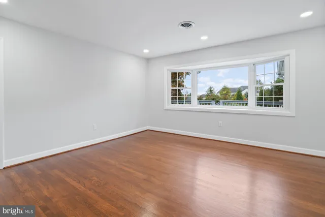 a view of an empty room with wooden floor