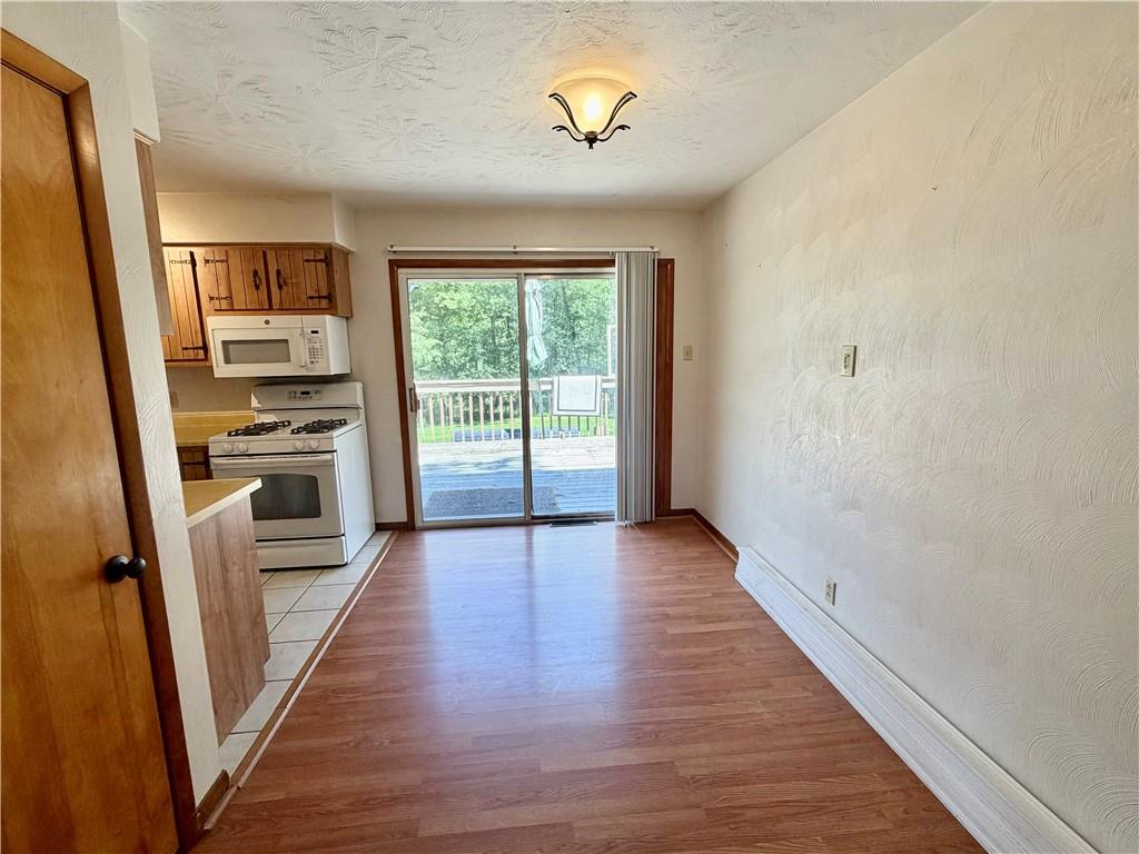121 Kemar Drive Butler, PA 16002 - Photo 11 of 31 wooden floor in an empty room with a kitchen