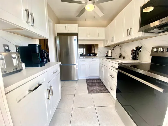 a kitchen with stainless steel appliances kitchen island granite countertop a stove sink and cabinets