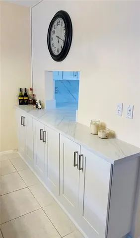 a kitchen with a sink a clock and cabinets