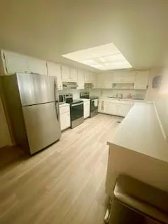 a kitchen with stainless steel appliances refrigerator oven table and chairs