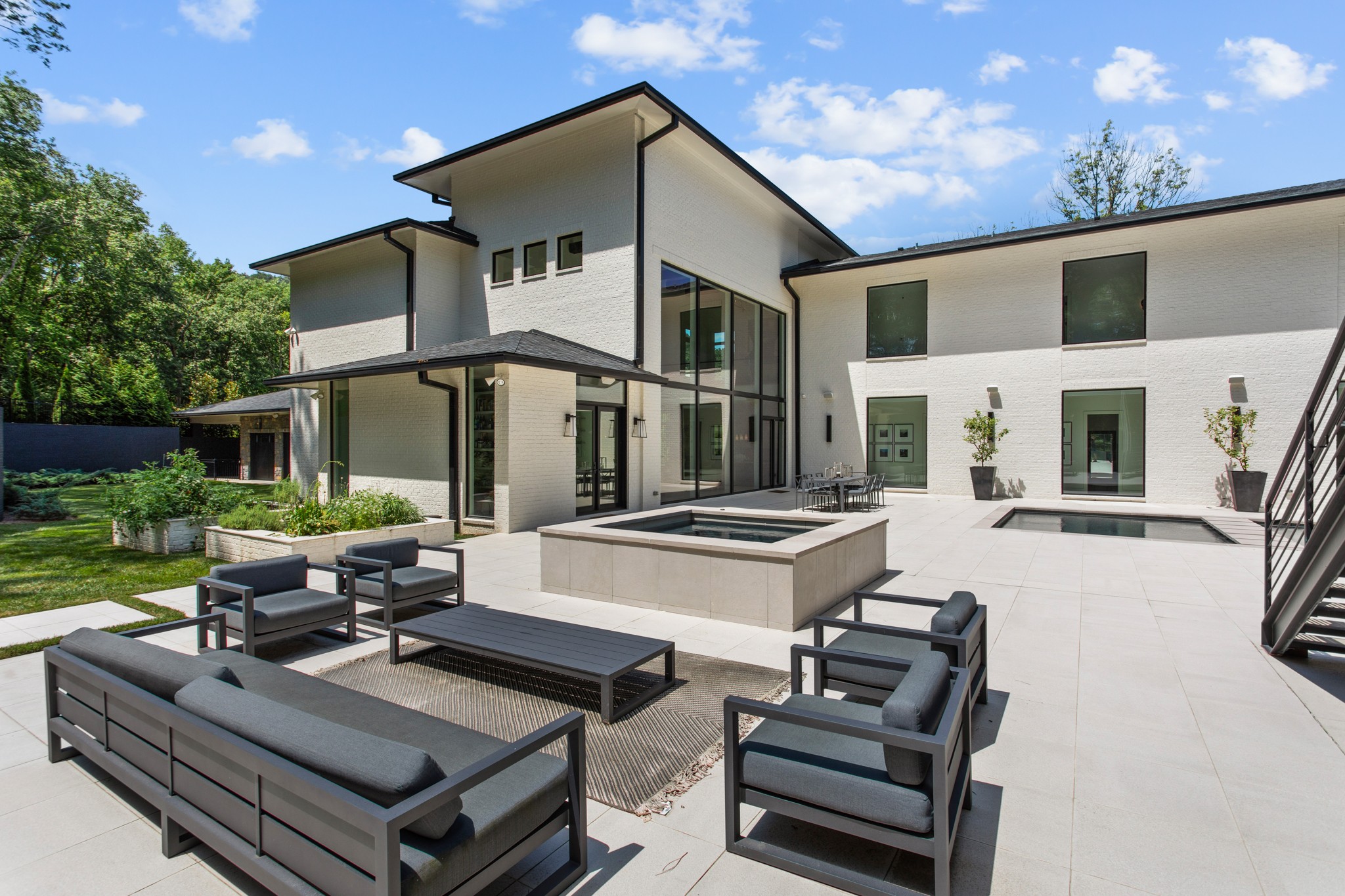 960 Overton Lea Road Nashville, TN 37220 - Photo 41 of 50 a view of a patio with couches table and chairs with potted plants and a palm tree