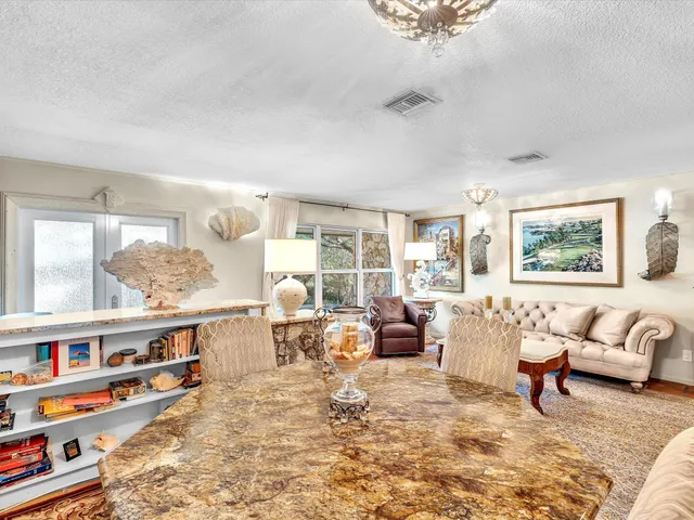 a view of a dining room with furniture and a chandelier