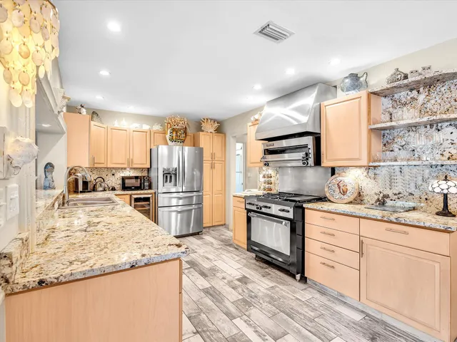a kitchen with kitchen island granite countertop a large window and a sink